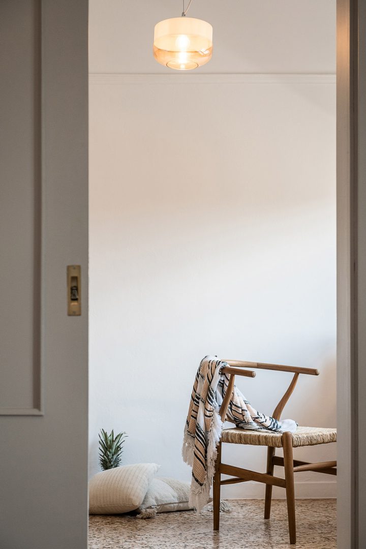 Hotel interior, a wooden chair with a blanket on it